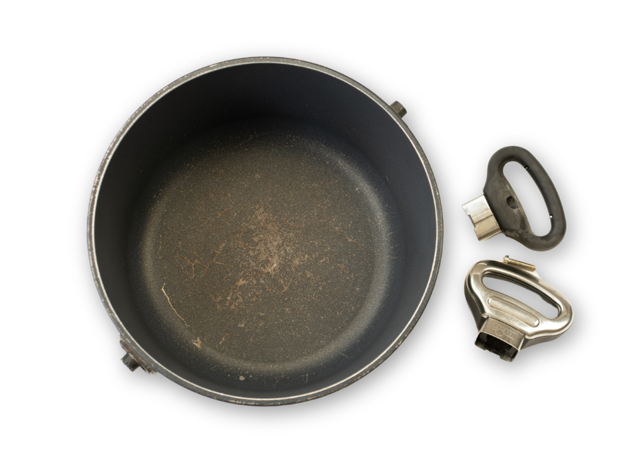 Old pot with removed handles shows signs of overheating