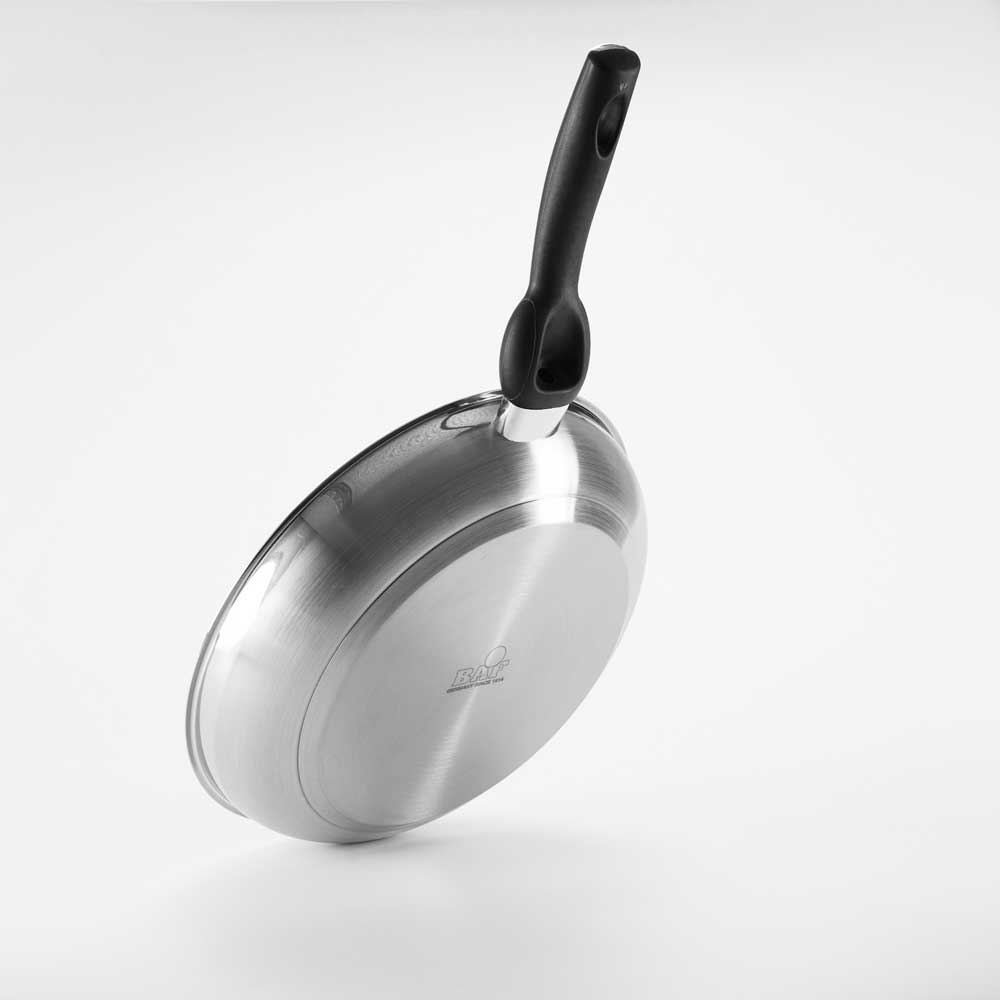Eine silberne Bratpfanne mit schwarzem Griff steht aufrecht auf einem weißen Untergrund. Sichtbar ist die Rückseite der Pfanne mit dem eingravierten BAF-Logo. Die Pfanne besteht aus Edelstahl und hat einen flachen, induktionsgeeigneten Boden.